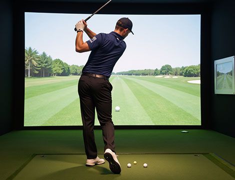 Man playing on home golf simulator