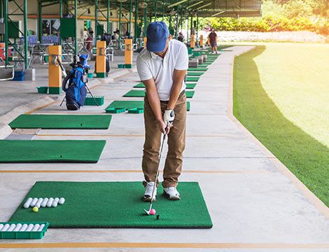 Man preparing to hit golf ball at range